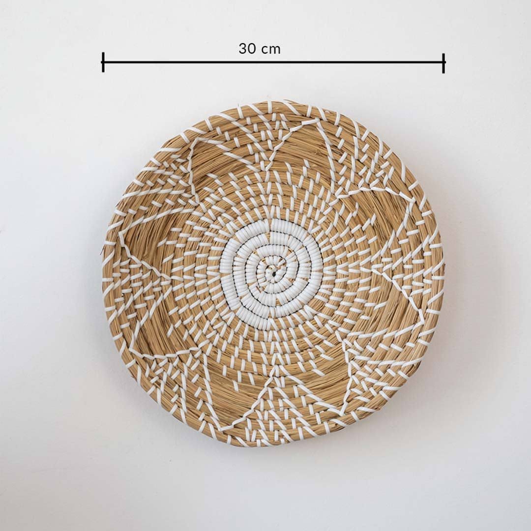 Handwoven seagrass round wall basket decor in natural beige with white spiral woven pattern and size guide on white.