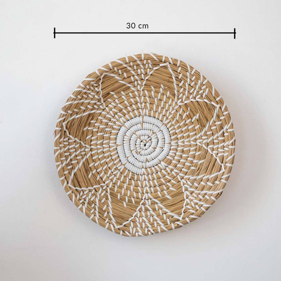 Handwoven seagrass round wall basket decor in natural beige with white spiral woven pattern and size guide on white.