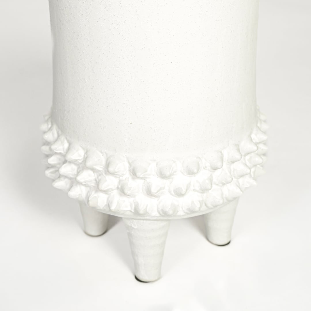Close view of white ceramic vase featuring textured detailing and smooth matte finish highlighting premium craftsmanship.