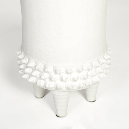 Close view of white ceramic vase featuring textured detailing and smooth matte finish highlighting premium craftsmanship.