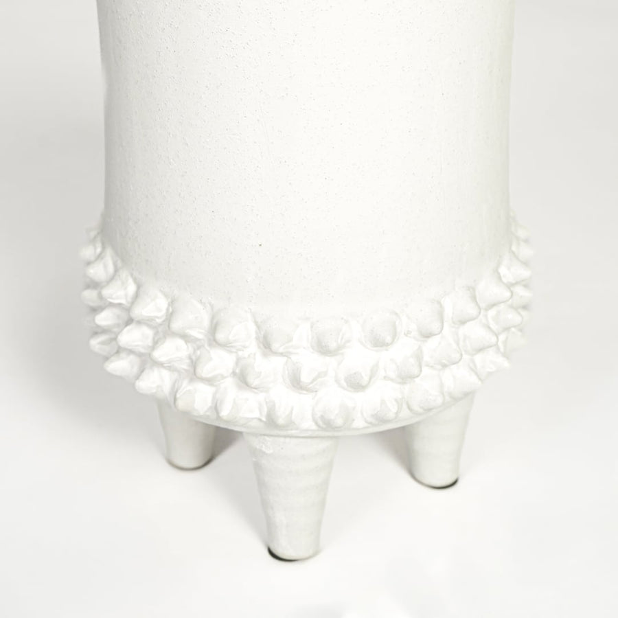 Close view of white ceramic vase featuring textured detailing and smooth matte finish highlighting premium craftsmanship.