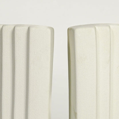 Close up view white ceramic bookends showing curved layered design smooth matte finish modern decor accent.