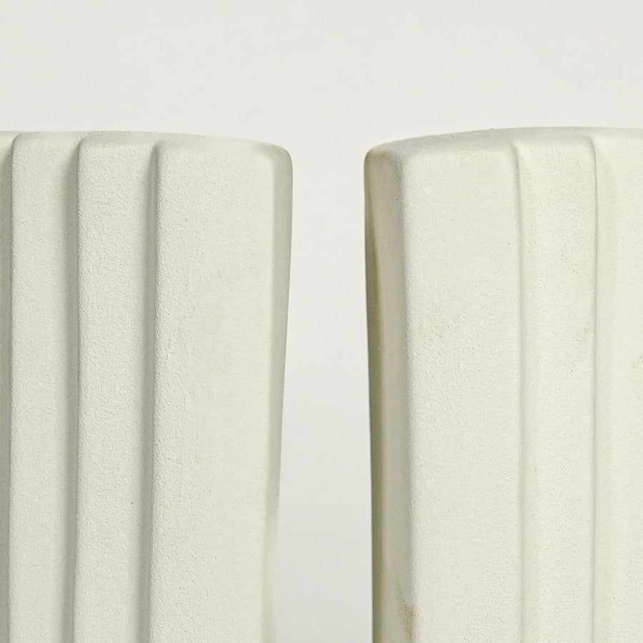 Close up view white ceramic bookends showing curved layered design smooth matte finish modern decor accent.