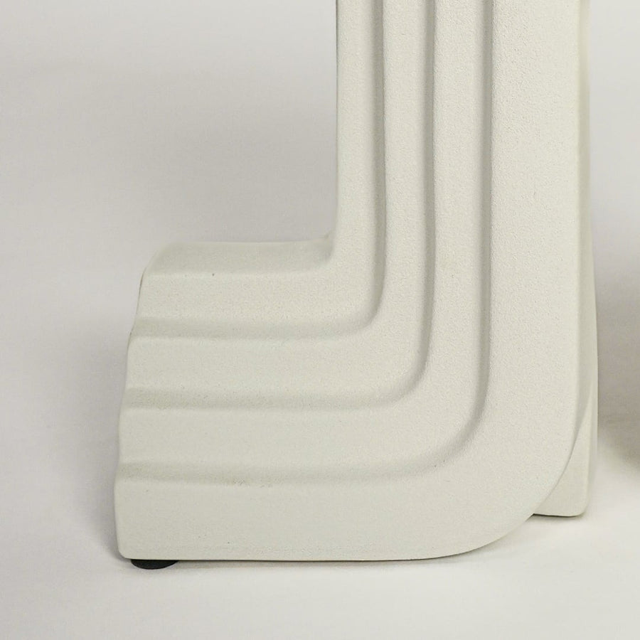 Close up view white sculptural bookends highlighting geometric shape clean edges modern ceramic decor styling piece.