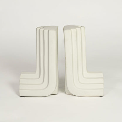 White ceramic modern bookends on white background minimal sculptural decor accessory for shelf or office styling.