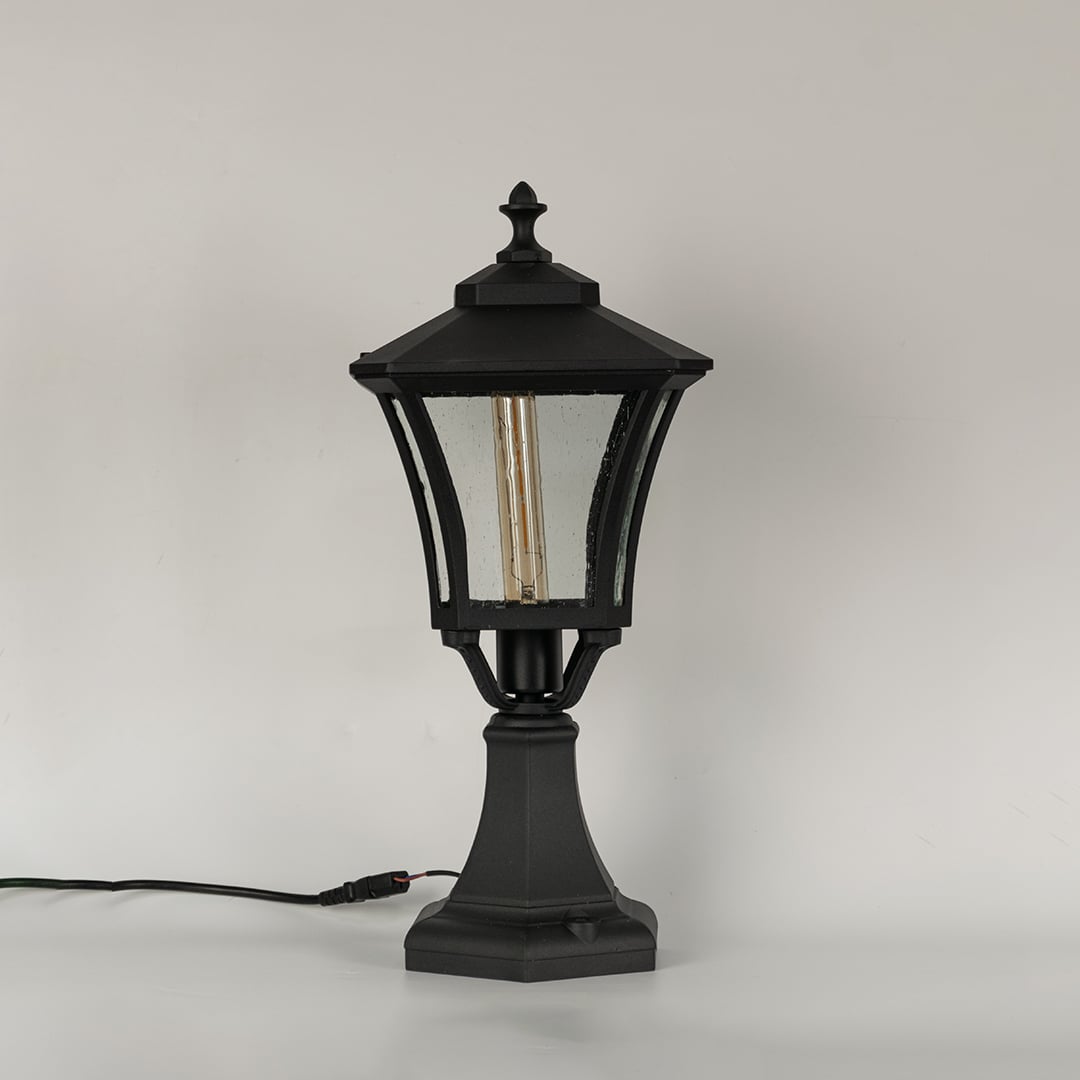 Black outdoor gate light with clear textured glass panels for stylish exterior decor use.