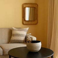 Cream round textured pot with black interior styled in a modern home setting adding soft minimal decor to shelves and tables.