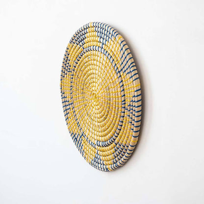Handwoven seagrass round wall basket decor in yellow and charcoal with raised woven profile displayed on white background.