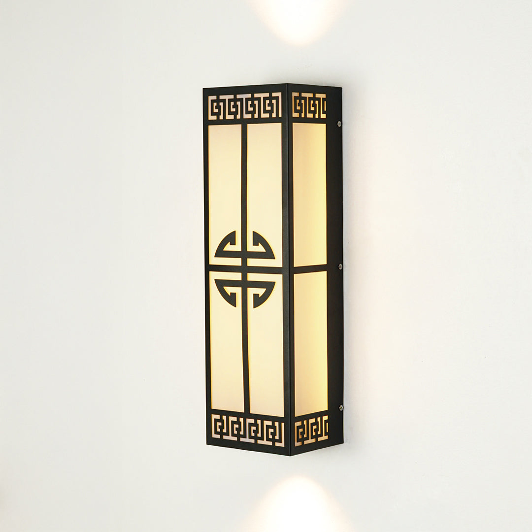 Decorative outdoor wall light with geometric metal pattern and frosted glass panel mounted on neutral wall background ideal for modern exterior lighting.
