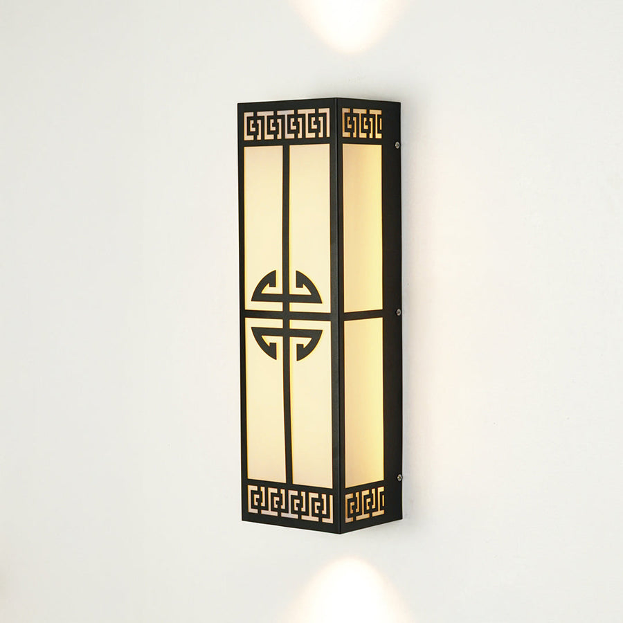 Decorative outdoor wall light with geometric metal pattern and frosted glass panel mounted on neutral wall background ideal for modern exterior lighting.
