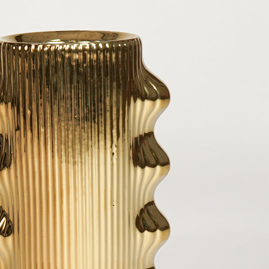 Closeup of gold finished metal vase with artistic raised detailing ideal for elegant home decor shelf or side table styling.