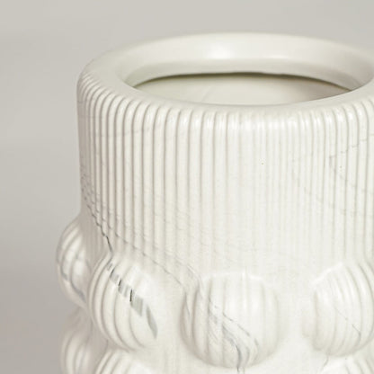 Closeup of matte white ceramic vase with embossed circular pattern ideal for elegant home decor shelf styling.