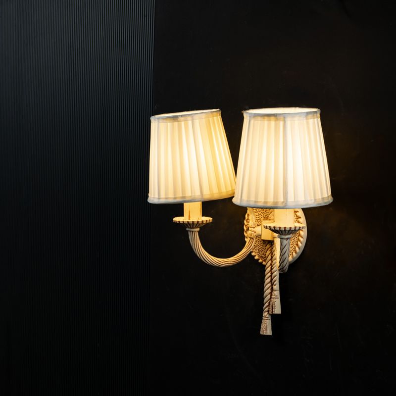 Antique 2 Light Wall Lamp with Pleated Fabric Shades Light On Black Background