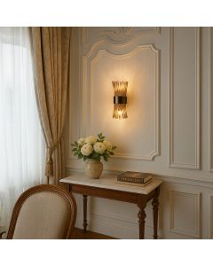 A gold metal and glass rod wall light glowing warmly in a classic interior setting adding soft ambient lighting to enhance elegant living room decor.