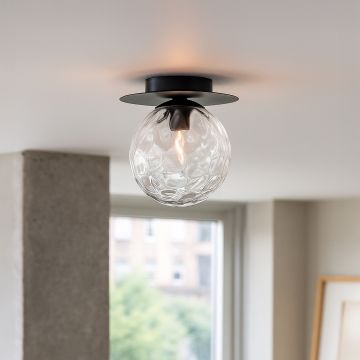 Modern ceiling light with textured glass globe and black frame glowing in living room for stylish home ceiling lighting.