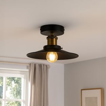 Industrial ceiling light with black metal shade and gold holder styled in modern living room with vintage bulb lighting.