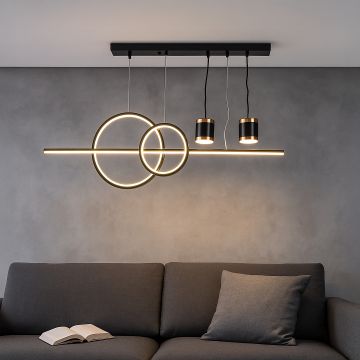 Modern pendant light with geometric rings and dual spotlights glowing above sofa for stylish living room interior decor.