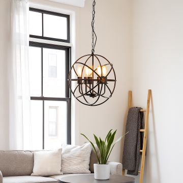 Black metal chandelier with spherical open frame and four glowing bulbs hanging above sofa for modern living room decor.