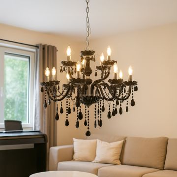 Black chandelier with crystal droplets glowing above sofa in modern living room for elegant luxury interior.