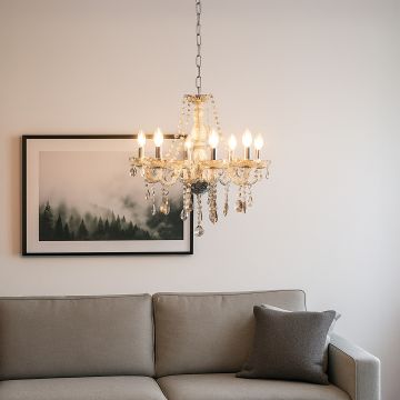 Golden crystal chandelier glowing above sofa in modern living room with wall art for stylish luxury decor.
