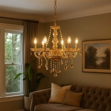 Golden chandelier with crystal droplets glowing above sofa in classic living room interior for luxury home decor.