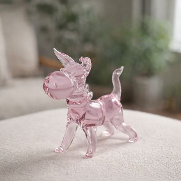 Pink glass dog figurine displayed on tabletop creating cute and playful accent for living room decor.