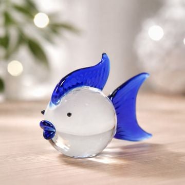 Blue and white glass fish figurine styled on table adding vibrant and artistic charm to contemporary home decor.