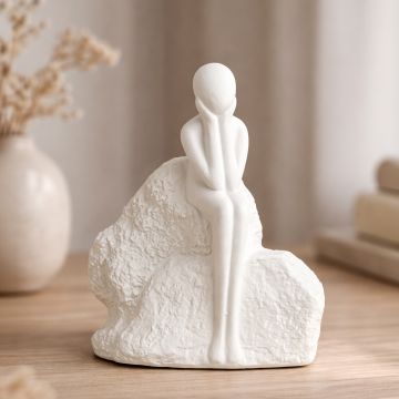 White ceramic abstract sitting human figurine sculpture styled on console table for modern living room decor accent.