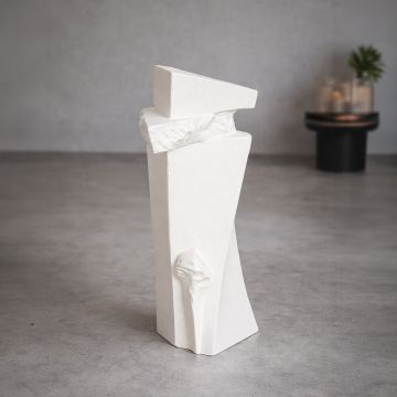 Tall white ceramic floor vase with sculpted texture styled in living room corner for modern decor accent.