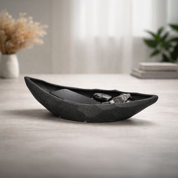 Black ceramic decorative platter placed on modern coffee table adding elegant contrast to contemporary living room decor.