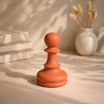 Orange ceramic sculpted decorative accent styled on tabletop enhancing warm and contemporary living room decor setting.