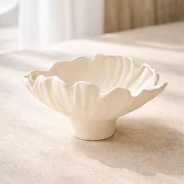 White ceramic floral decorative bowl styled on coffee table enhancing soft and elegant home decor setting.