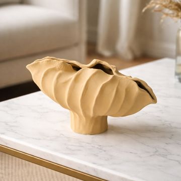 Yellow ceramic sculpted decorative bowl displayed on tabletop creating bold and contemporary interior decor accent.