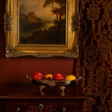 Oval silver tray with gold handles and decorative feet displayed on white background with shiny surface finish.