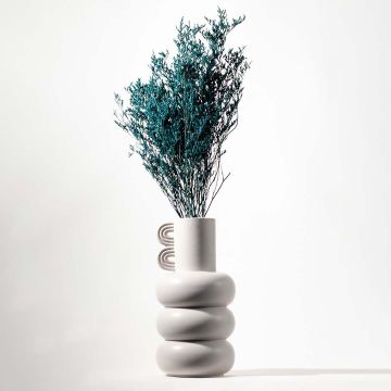 Teal preserved limonium foliage styled in modern white ceramic vase perfect for elegant living room floral decor and interiors.