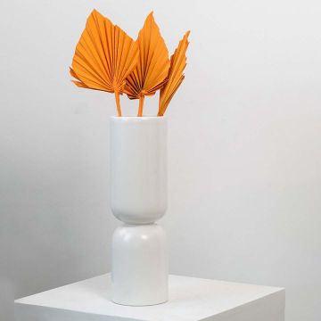 Orange dried palm leaves in tall white vase styled for modern home decor and table decoration.