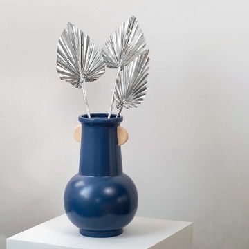 Silver dried palm leaves in blue ceramic vase styled for modern boho home decor and table decoration.