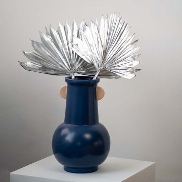 Silver dried palm leaves in blue ceramic vase styled for modern home decor and boho table decoration.
