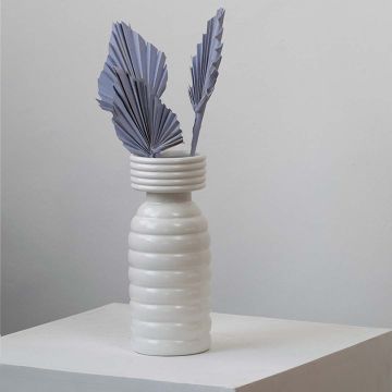 Light purple dried palm leaves in ribbed white vase styled for modern boho home decor and table decoration.