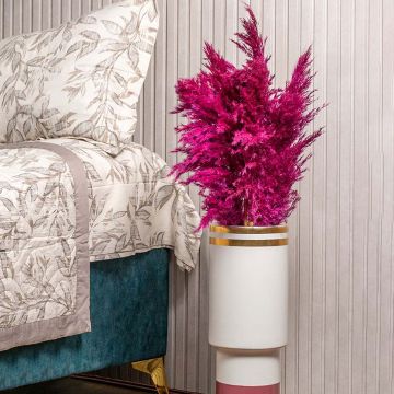 Magenta pampas grass styled in tall designer vase placed beside bed for luxury bedroom and modern home decor.