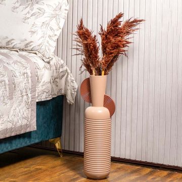 Brown pampas grass styled in tall designer vase placed beside bed for elegant bedroom and modern home decor.