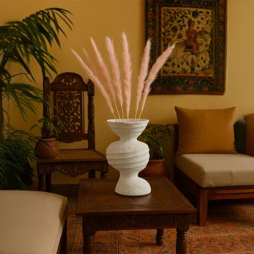 Soft pink pampas grass stems displayed in rustic modern vase minimal boho style decor for living spaces.