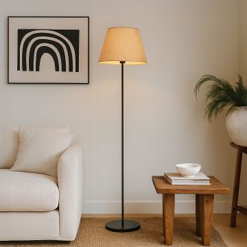 Beige floor lamp with fabric shade styled beside a modern sofa and wooden side table in a cozy living room setup.