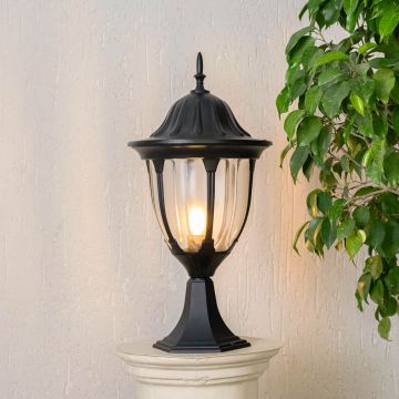 Elegant outdoor black pillar lamp glowing warmly with LED bulb inside clear glass panels perfect for patio driveway and gate.