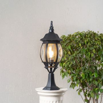 Elegant outdoor black pillar light glowing warmly with clear rounded glass panels perfect for patio driveway and terrace.