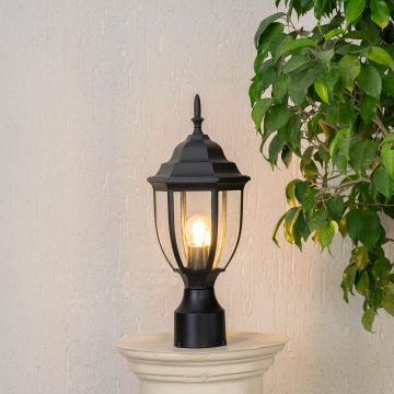 Outdoor black pillar lamp glowing with warm LED bulb and clear glass shade perfect for patio driveway and garden use.