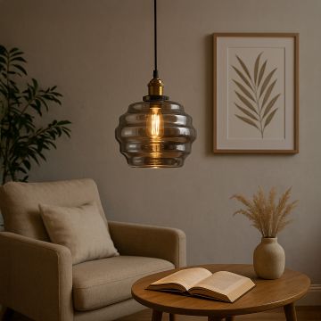 Rippled smoked glass pendant light glowing warmly above a reading corner with a soft armchair wood table open book and minimal wall art enhancing the calm setting.