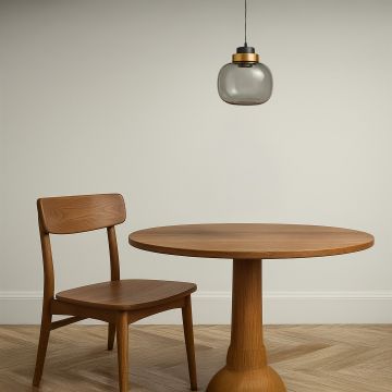 Smoked glass pendant light with golden accent hanging over wooden dining table modern ceiling lamp for home interior styling.