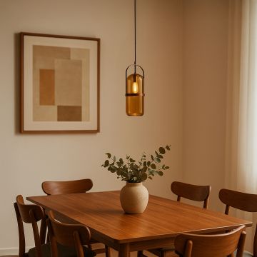 Amber glass pendant light with golden frame hanging over dining table adds warm modern charm to home decor.