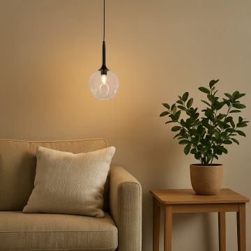 Stylish glass pendant light adding soft illumination to a balcony corner with chair and plant decor.